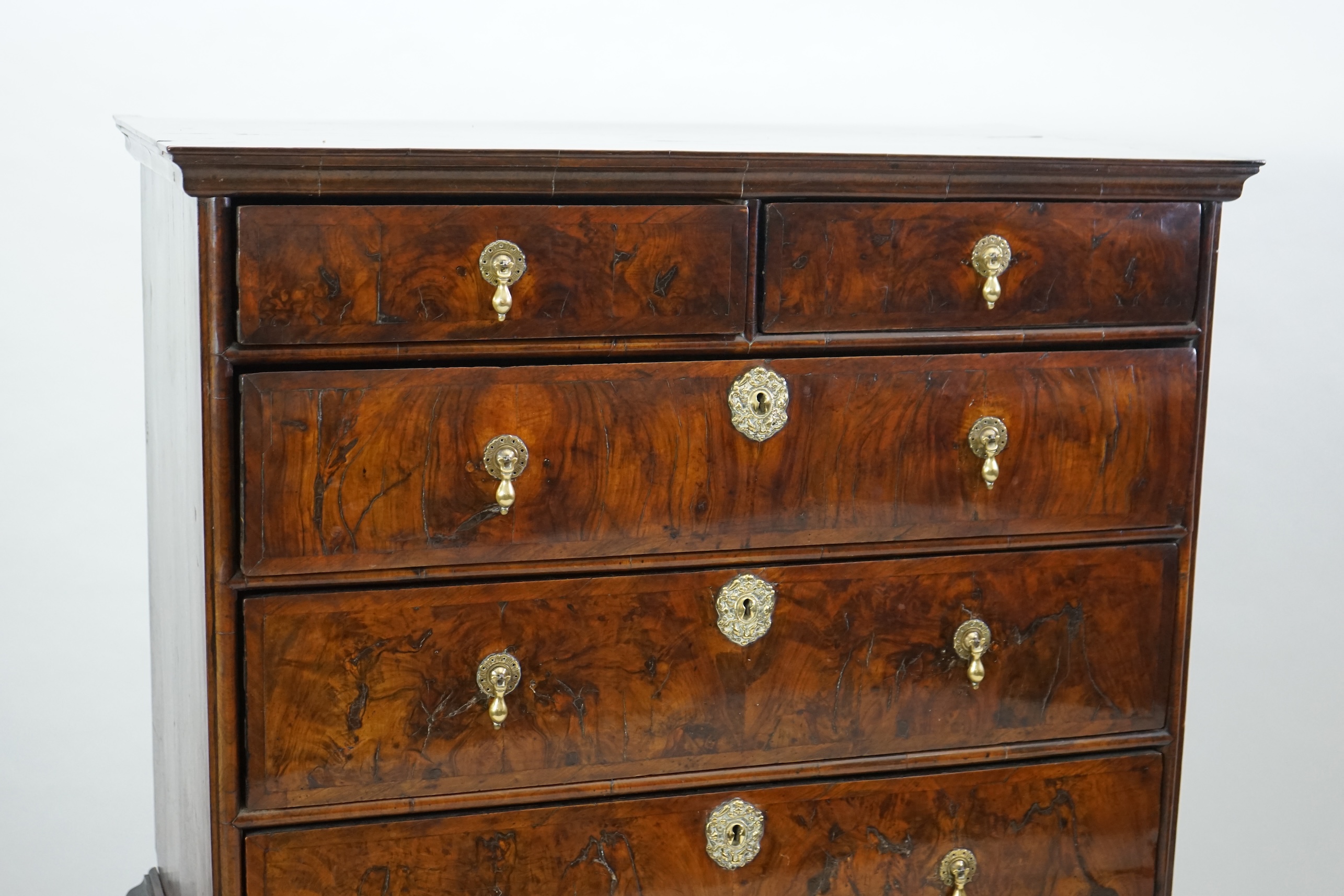 An early 18th century and later crossbanded walnut chest on stand